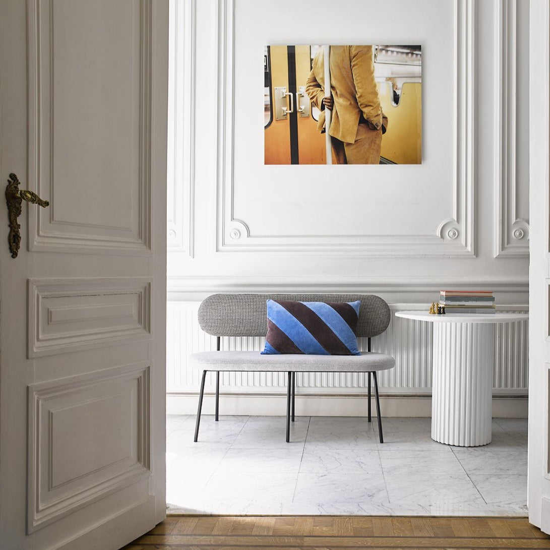 hallway with marble floor, gey upholstered bench and yellow art photo