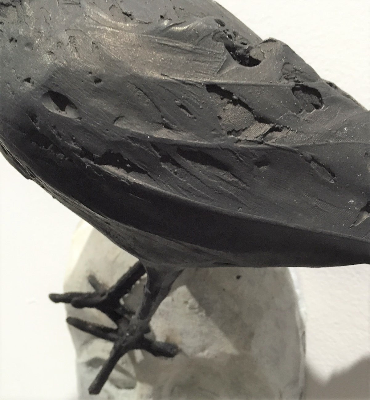 detail of bird that is on top of face bronze